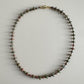 Necklace with small beads on a light gray background