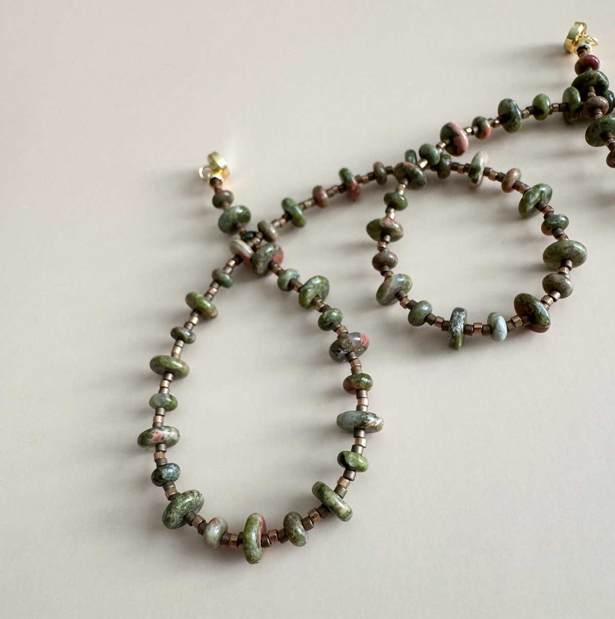 Beaded necklace with unakite 2mmx4mm beads on a light background