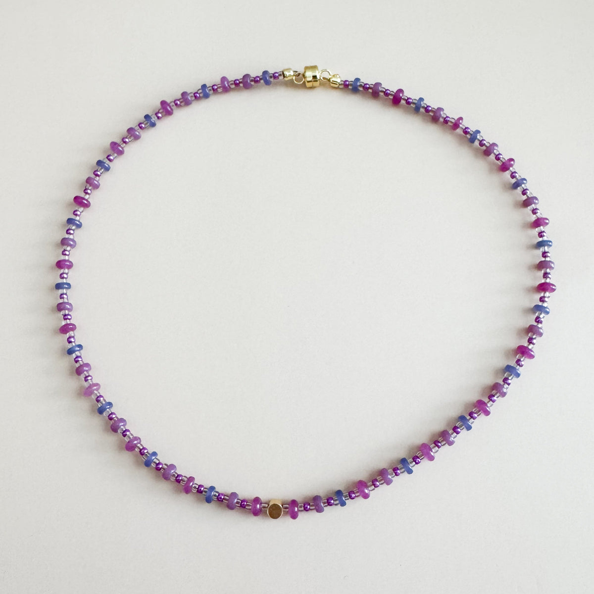 Multicolored beaded necklace on a light gray background
