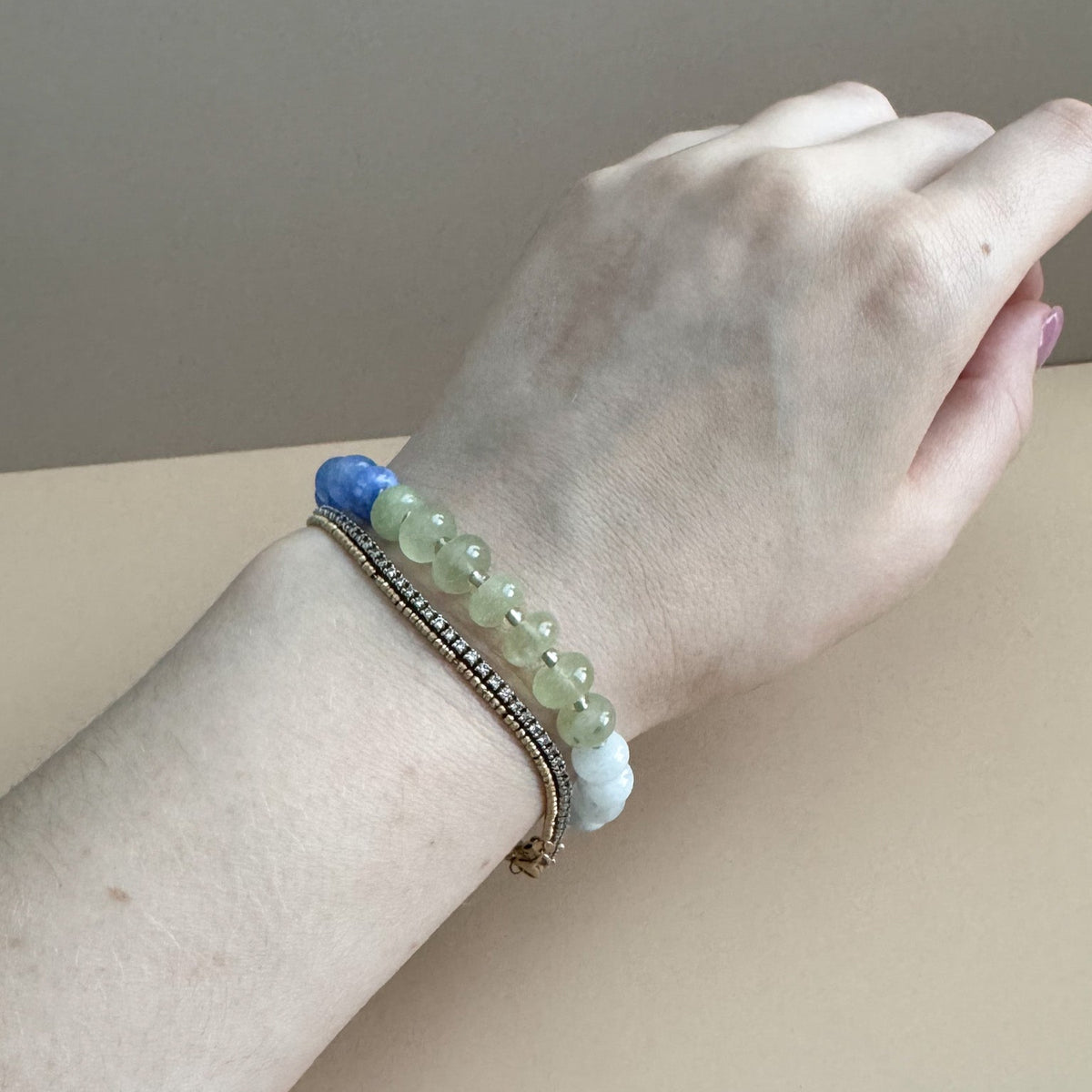 Beaded bracelet with vibrant blue, light blue, and green beads on a woman's wrist