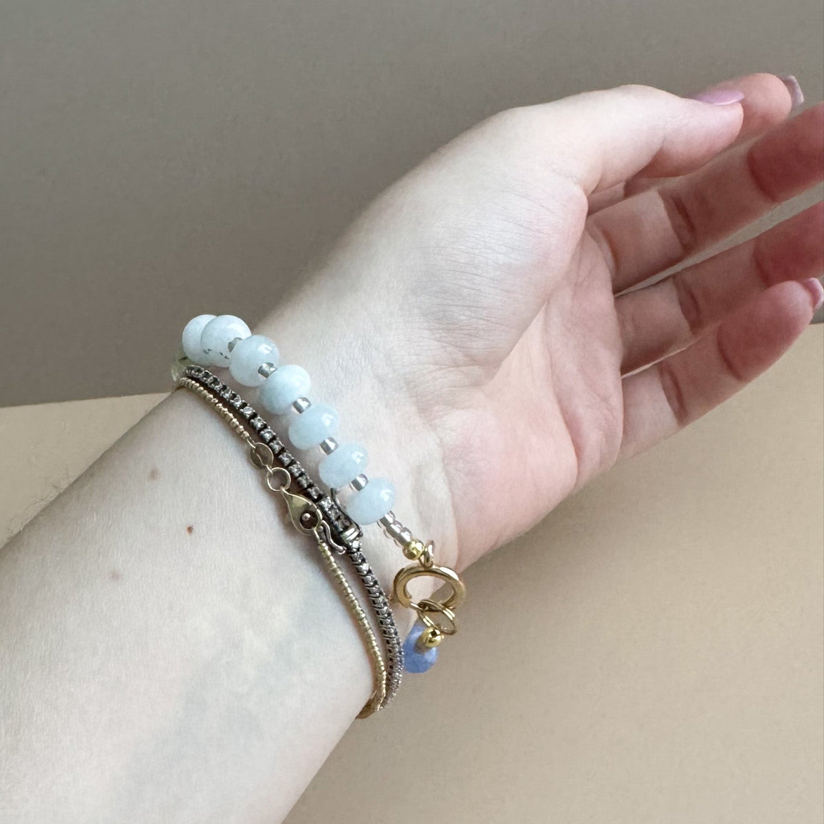 Beaded bracelet with vibrant blue, light blue, and green beads on a woman's wrist.